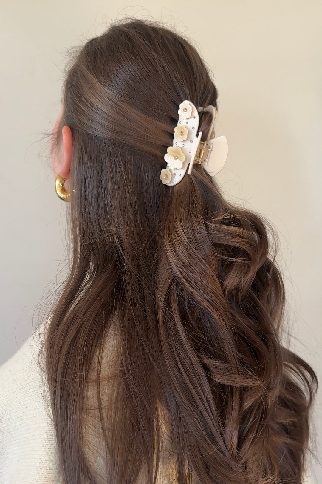 Model met half opgestoken haar draagt beige haarklem van acetaat, perfect voor een casual look.