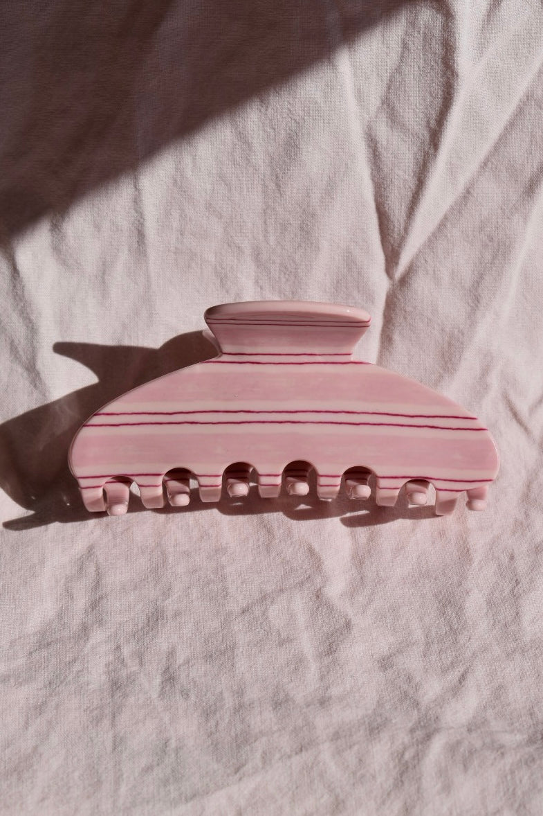 Detail van roze gestreepte haarklem met minimalistisch design, geschikt voor dagelijks gebruik bij elk haartype.