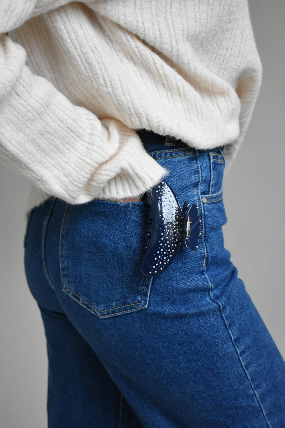 Close-up van witte pareldetails op navy haarklem – elegant design met glanzend acetaat