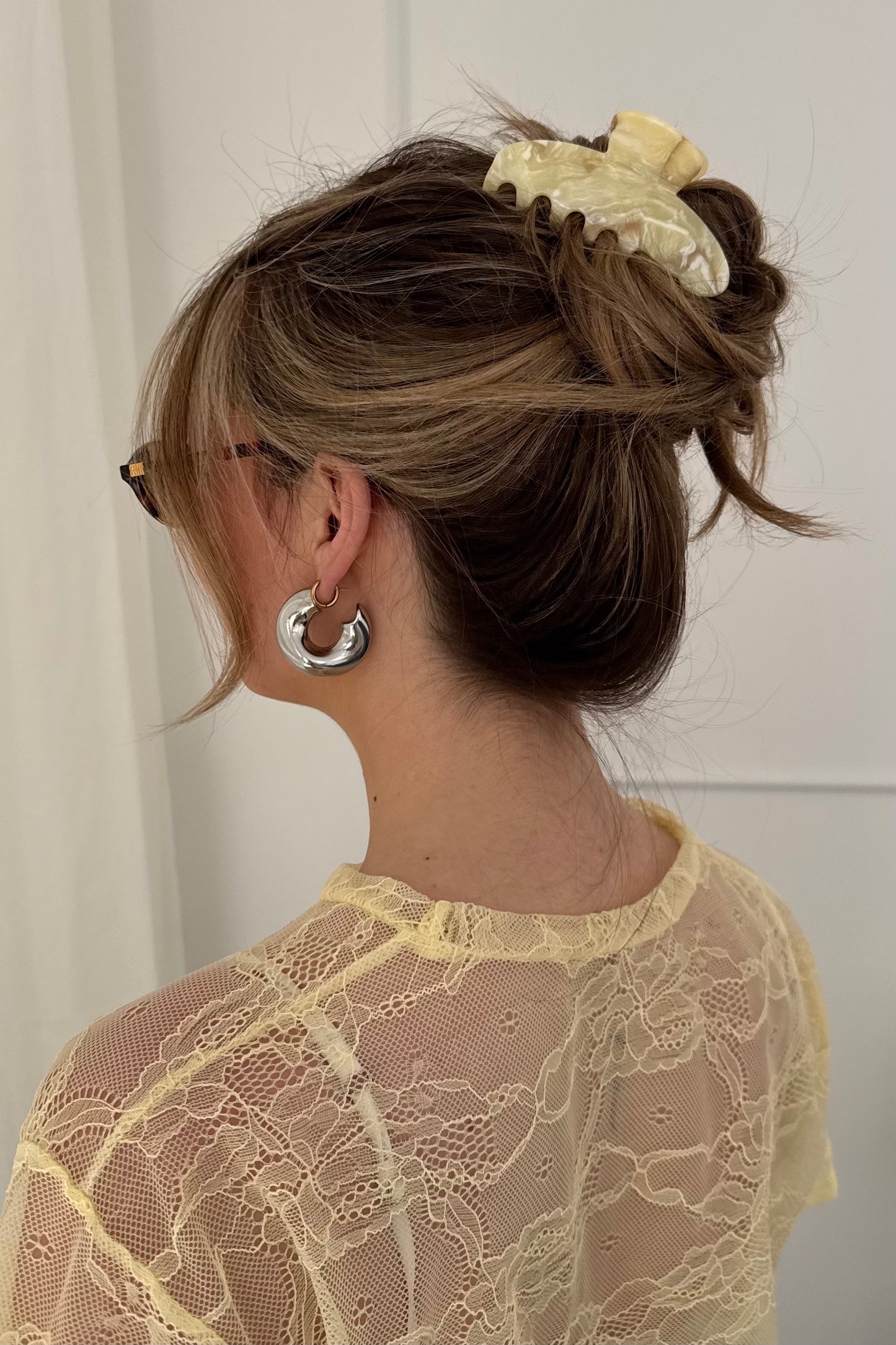 Honey botergele haarklem vastgezet in casual kapsel, gedragen door model met middellang haar.