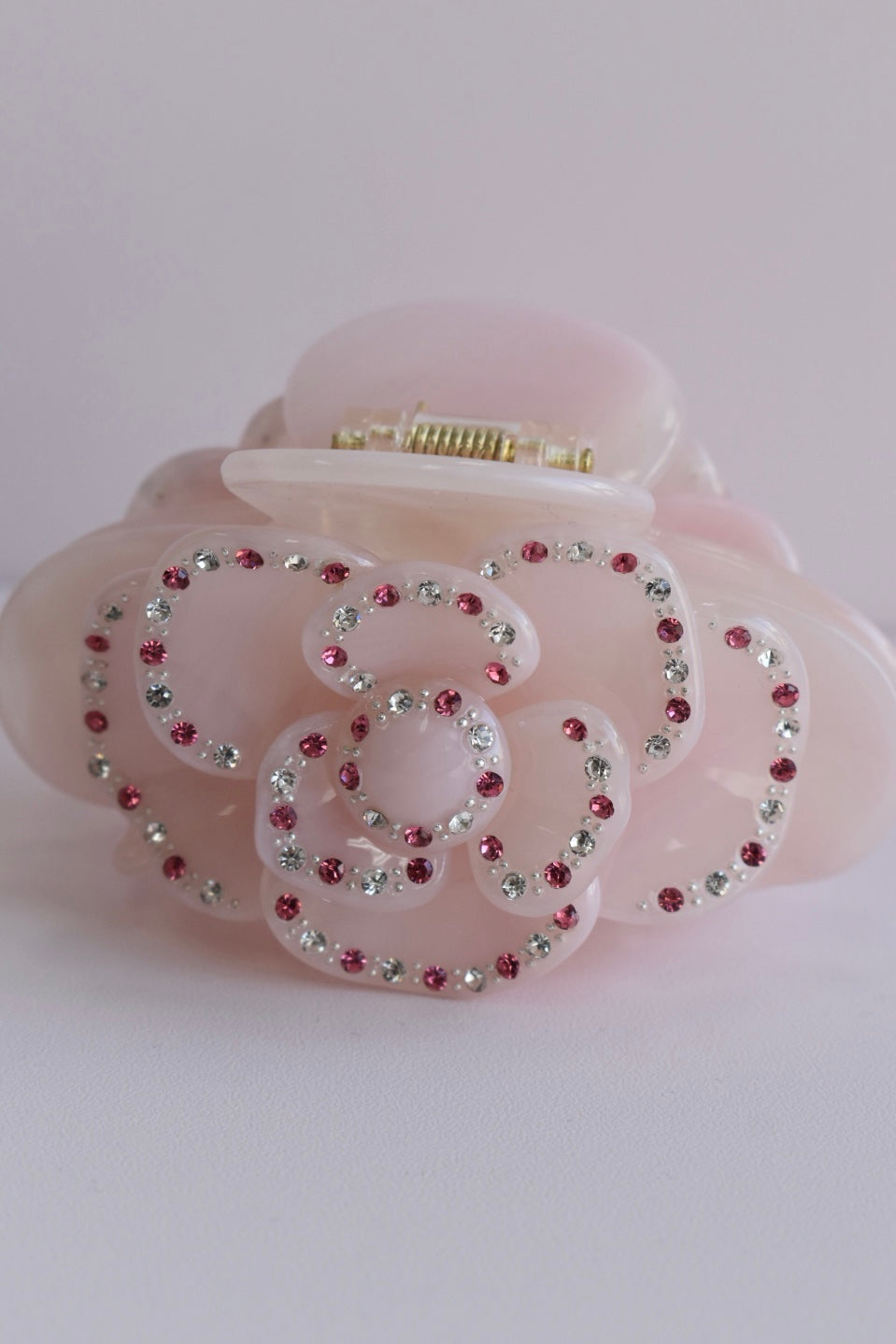 Trendy roze haarklem met glinsterende steentjes en verfijnd roosdetail, perfect als eyecatcher bij iedere outfit.