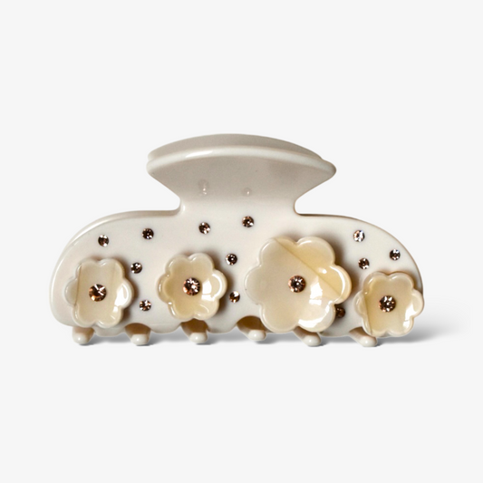 Beige haarklem met verfijnde bloemdetails, een subtiel en vrouwelijk accessoire voor de lente.