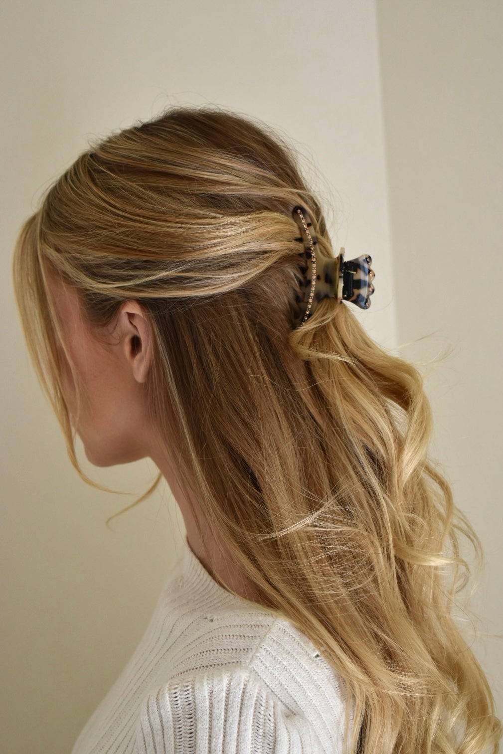 Model met blond haar draagt acetaat haarclip in luipaard trend