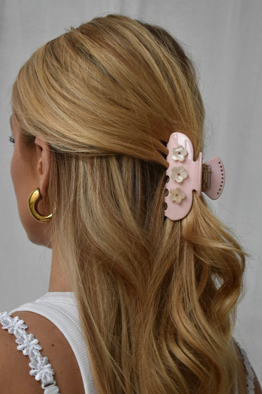 Detail foto van roze haarklem in blond haar, trendy lente en zomer haaraccessoire voor vrouwen