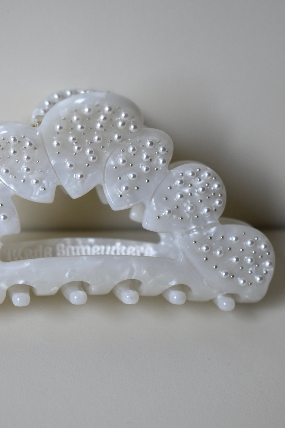 Close-up van parelversiering op witte haarklem – elegante glans en verfijnd ontwerp