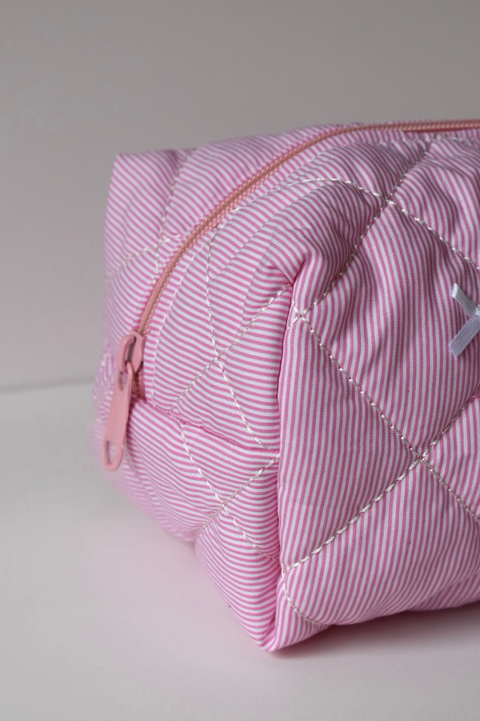 Trendy roze make-up tas met strikjes, perfect voor het organizen van skincare.