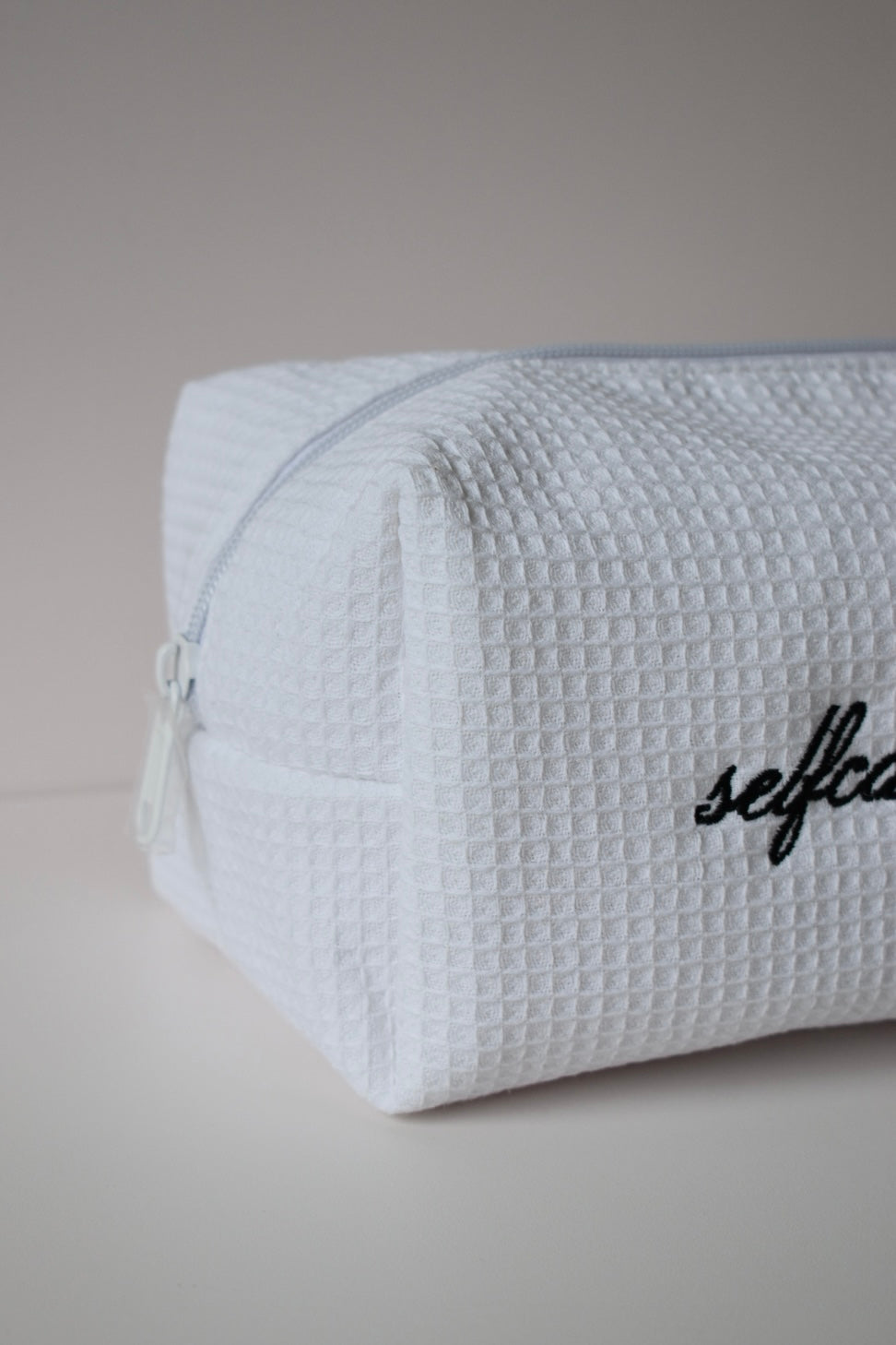 Detail van witte make-up pouch met wafelstof, praktisch én trendy