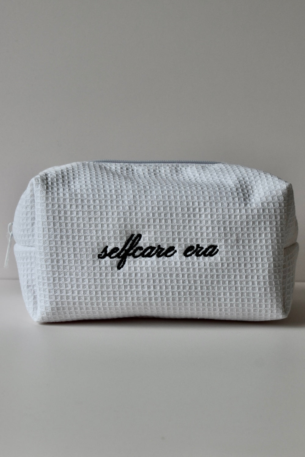 Compacte witte toilettas in minimalistische look, perfect voor in je handtas of op reis.