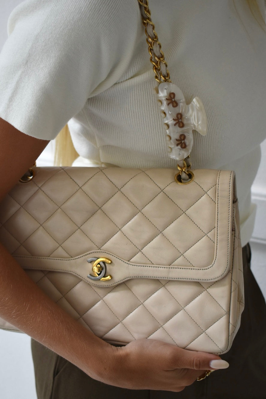 The bow hair claw clip on a beige chanel flap bag