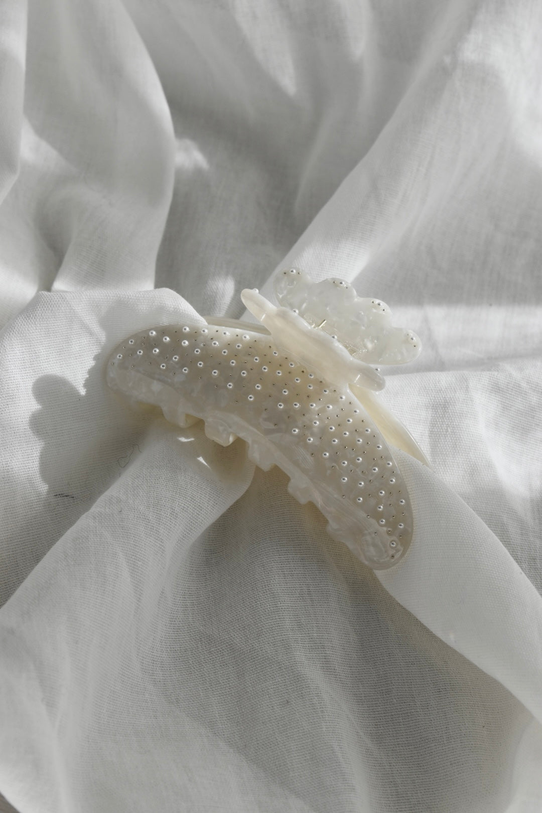 Close-up van witte pareldetails op witte haarklem – elegant design met glans